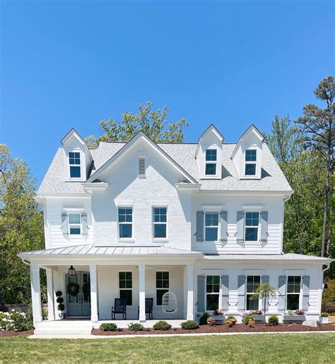 white house with blue metal roof|white house navy blue shutters.